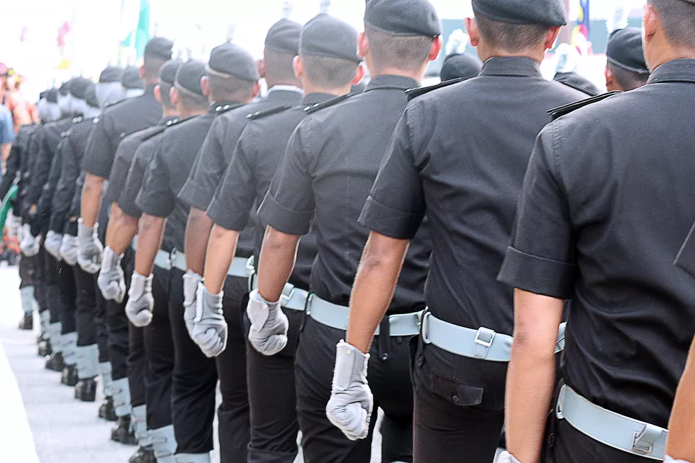 rear-view-men-uniform-standing-road