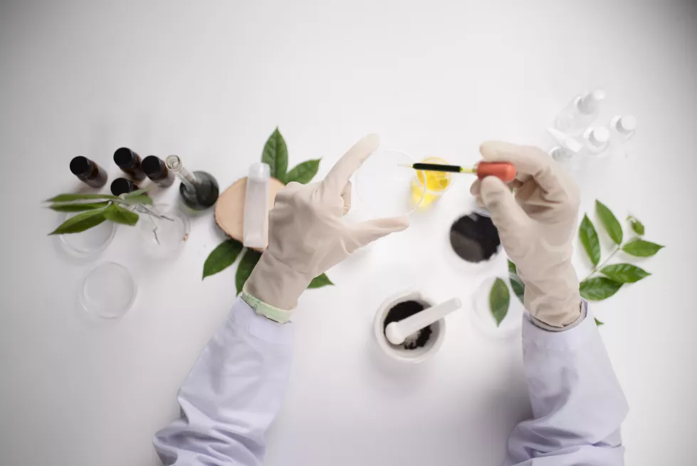 scientist-hand-holding-green-leaf-glass-cuvette-laboratory-biotechnology-concept