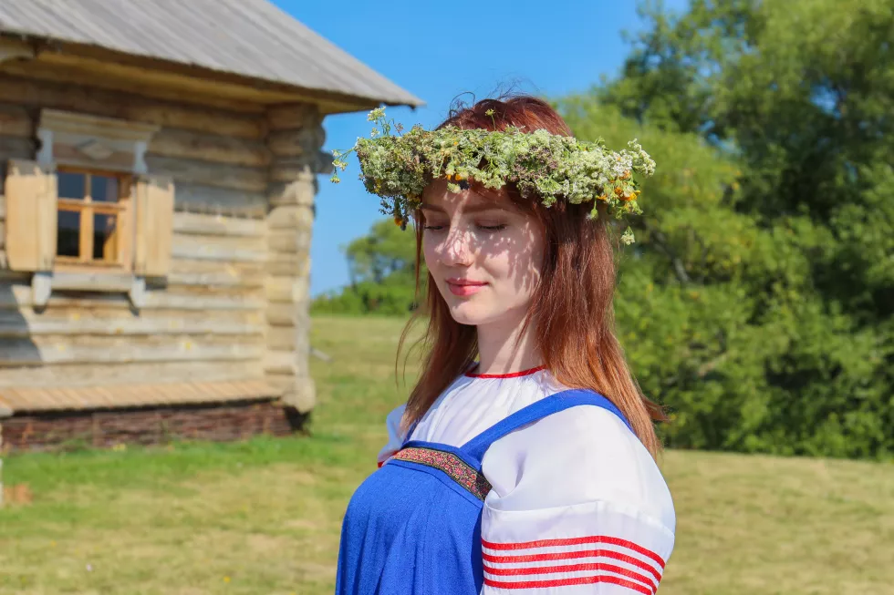 beautiful-young-woman-wearing-flower-tiara-standing-against-trees