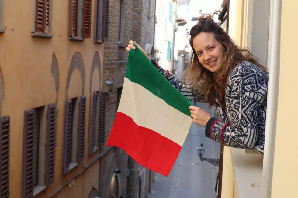 portrait-woman-holding-flag-while-standing-balcony