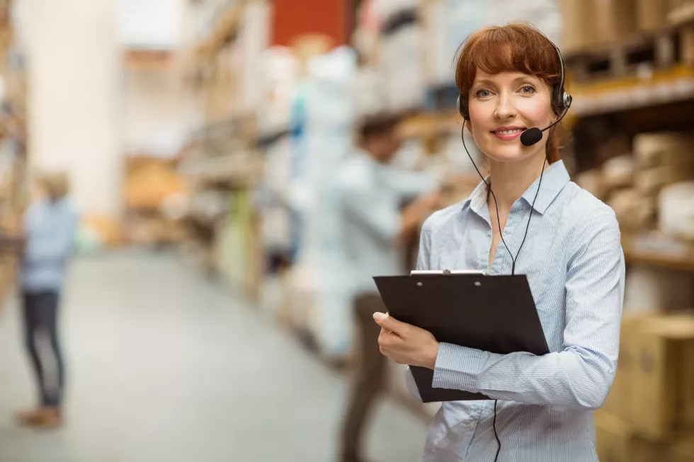 manager-wearing-headset-while-holding-clipboard