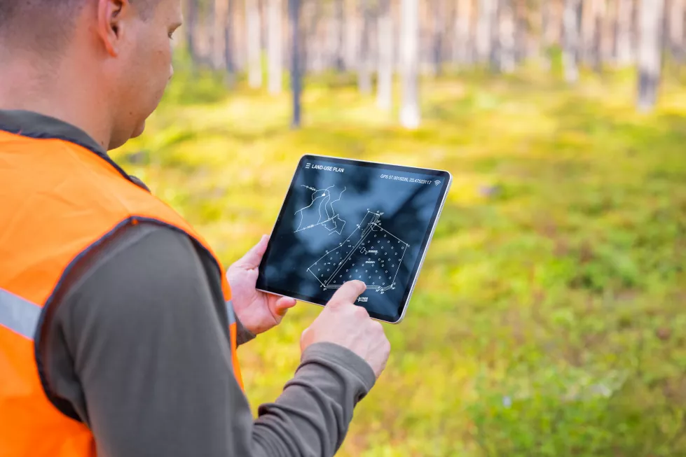 forester-using-tablet-computer-forest-looking-topological-map-land-plan-screen