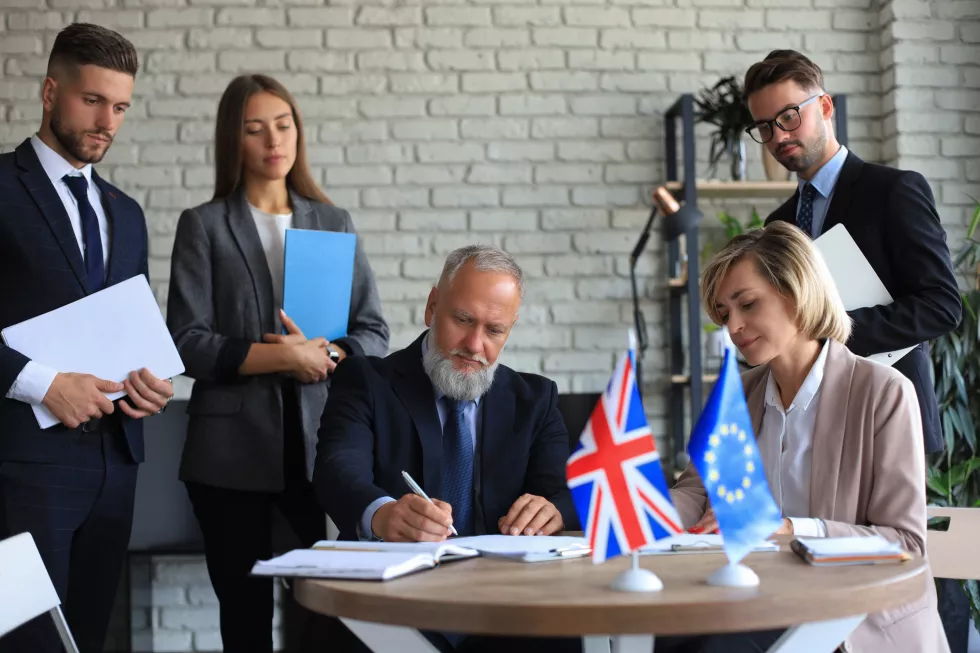 two-business-partners-signing-document-european-union-united-kingdom(1)
