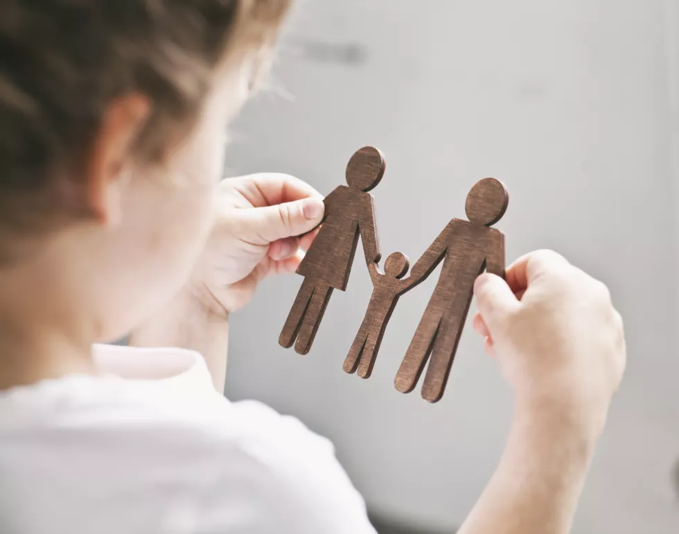 little-child-looking-wooden-figures-mom-dad-child-his-hands-concept-child-dreaming-about-family(1)
