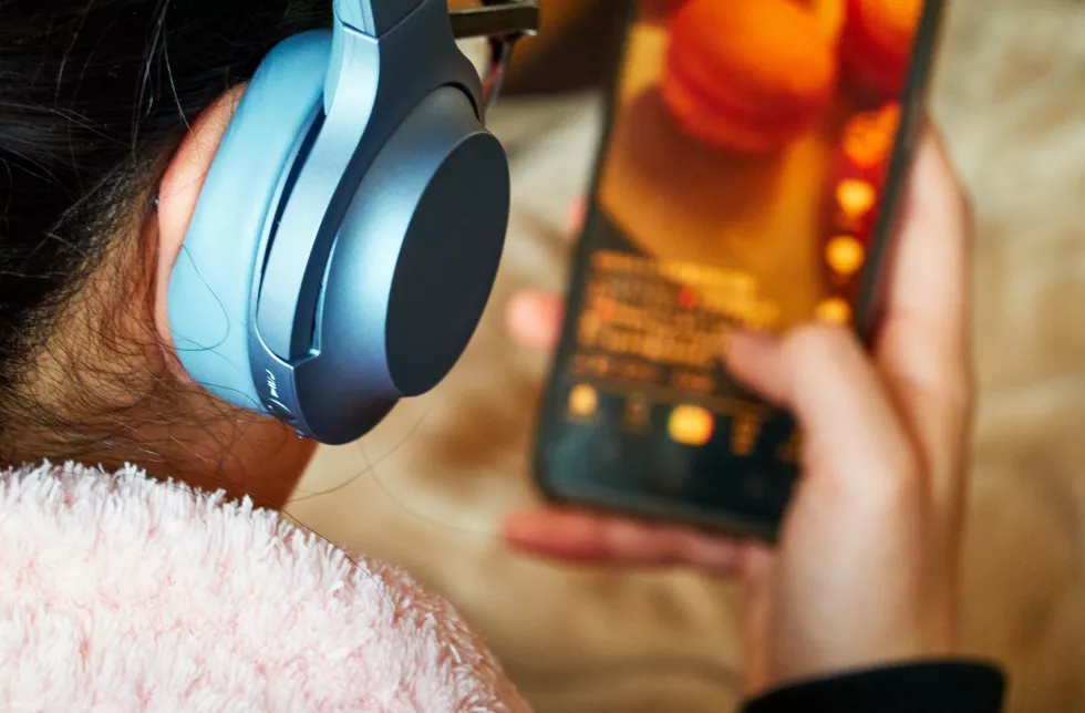 rear-view-teenage-girl-using-mobile-phone-with-headphones