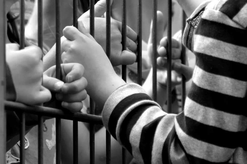 cropped-hands-holding-metal-gate