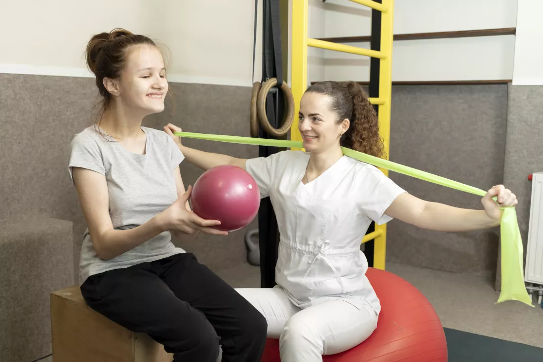 smiling-child-teenage-girl-with-disability-does-physical-exercises-with-support-rehabilitation