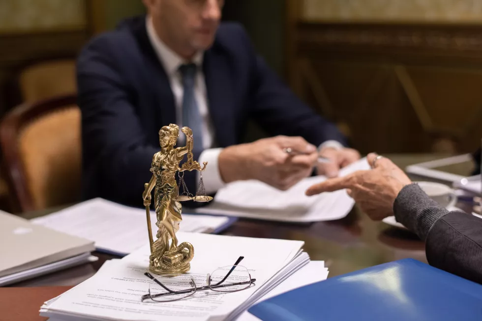statue-justice-eyeglasses-stack-juridical-papers