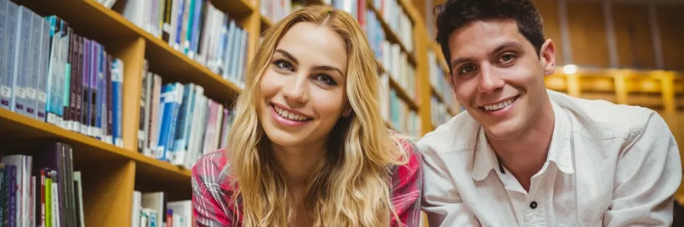 English-Studies-test-usmiechnieci-studenci-z-ksiazkami-w-bibliotece