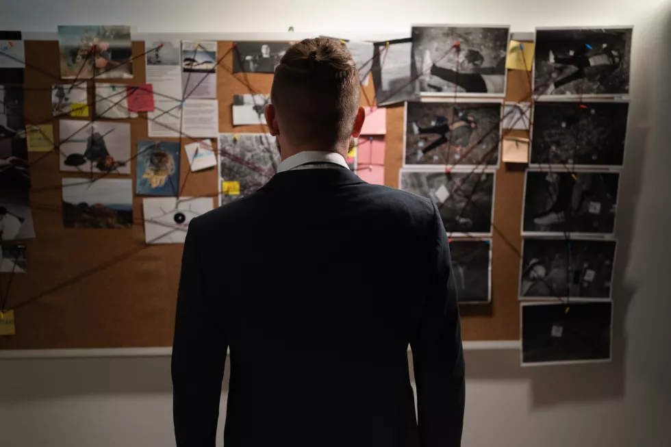 male-detective-office-near-blackboard-looking-killer-working-night-view-from-back-without-face
