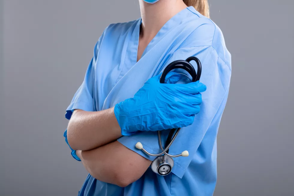 midsection-caucasian-female-doctor-holding-stethoscope-isolated-grey-background-medical-healthcare-services-concept