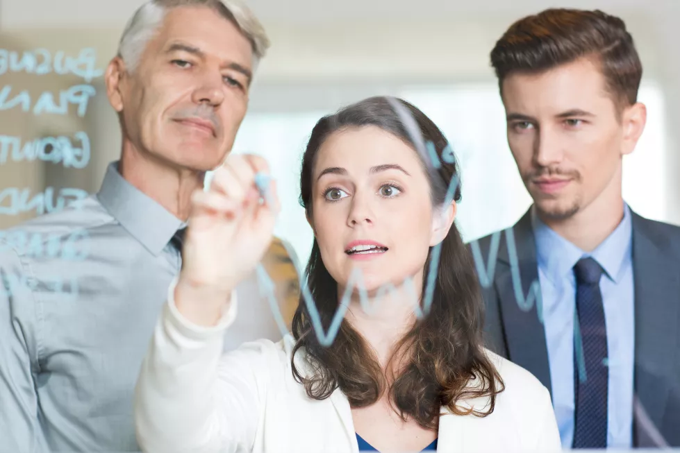 young-businesswoman-drawing-graph-with-colleagues
