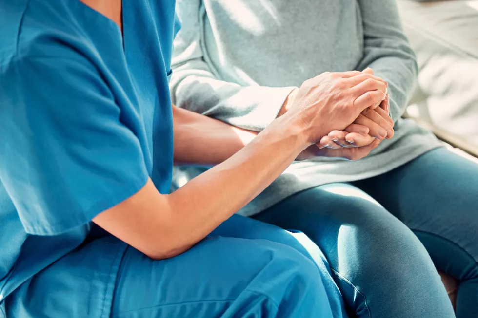 holding-hands-support-nurse-with-senior-patient-care-trust-nursing-home-people-retirement-caregiver-help-elderly-woman-person-with-medical-cancer-advice