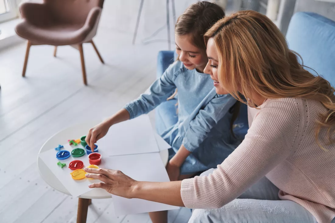 let-us-learn-something-new-top-view-mother-daughter-touching-paints-smiling-while-spending-time-home