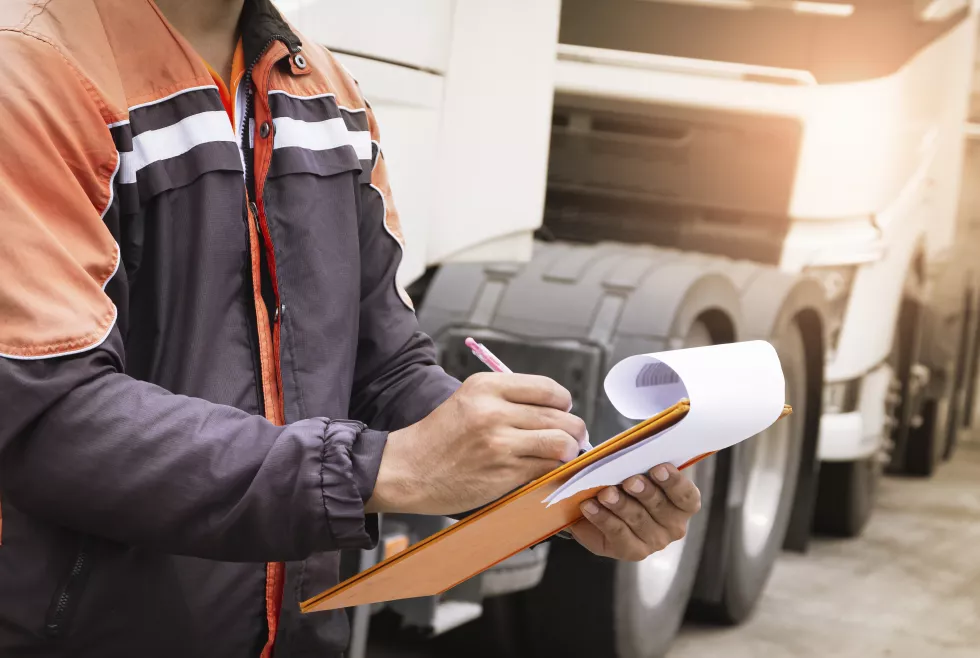 auto-mechanic-driver-holding-clipboard-is-checking-maintenance-safety-program-semi-truck