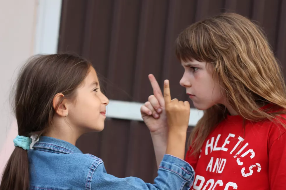 sisters-pointing-while-standing-face-face