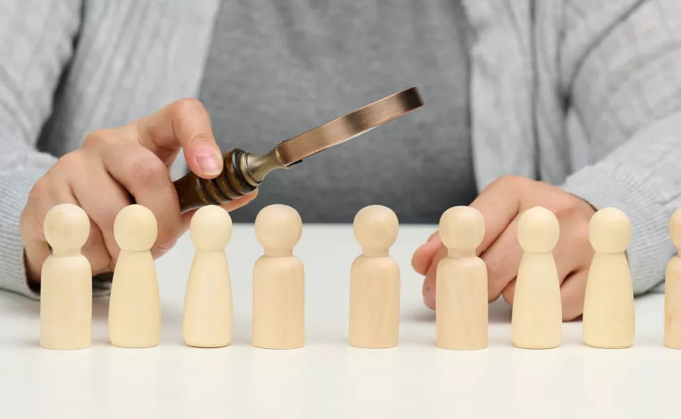 figurines-men-white-table-female-hand-holds-magnifying-glass-one-concept-searching-employees-company-recruiting-personnel-identifying-talented-strong-personaliti