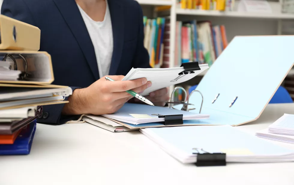 man-working-with-documents-table-archive