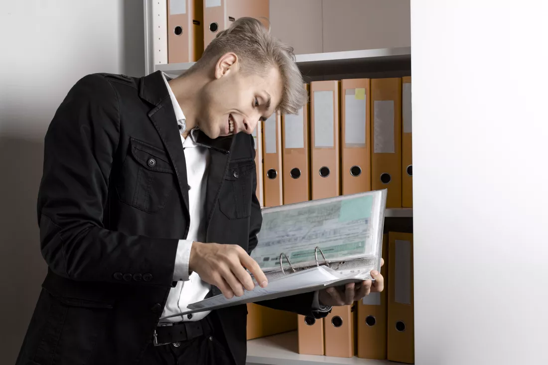 successful-businessman-reading-documents-talking-phone-office