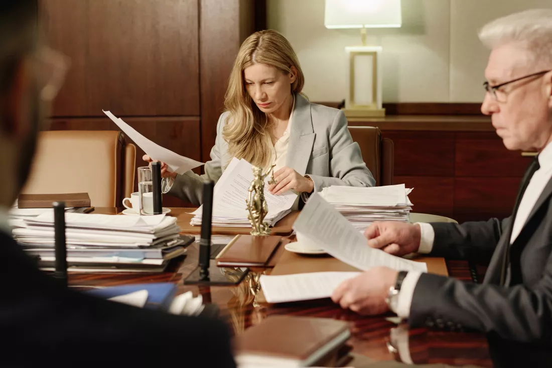 female-lawyer-doing-paperwork-together-with-male-coworkers