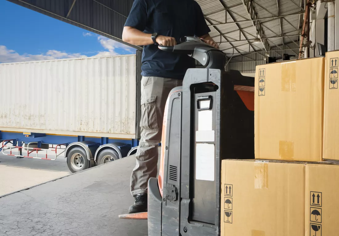 warehouse-worker-driving-forklift-pallet-jack-unloading-pallet-goods