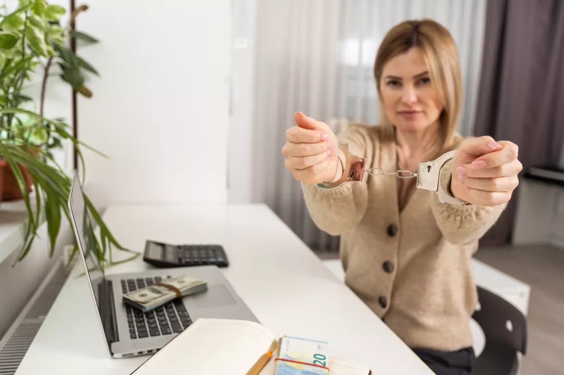 woman-with-handcuffs-laptop-pays-taxes