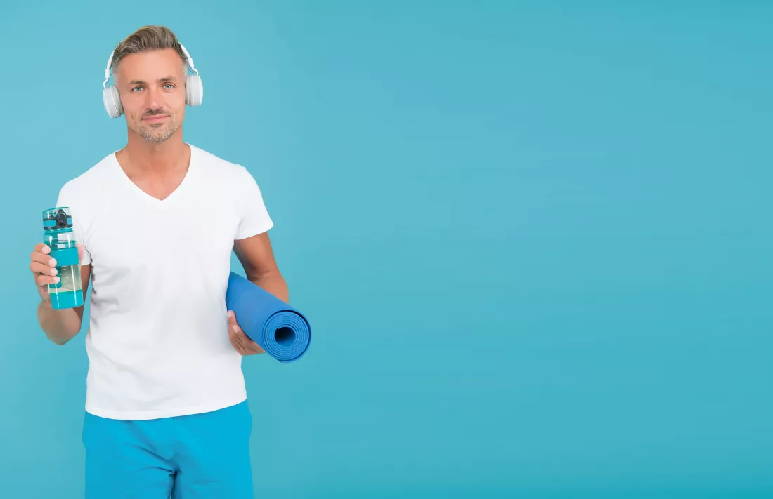 choose-sport-drink-wisely-athletic-man-hold-sport-bottle-gym-mat-handsome-sportsman-blue-background-hydration-athletes-sport-diet-health-recreation-fluids-sport-copy-space
