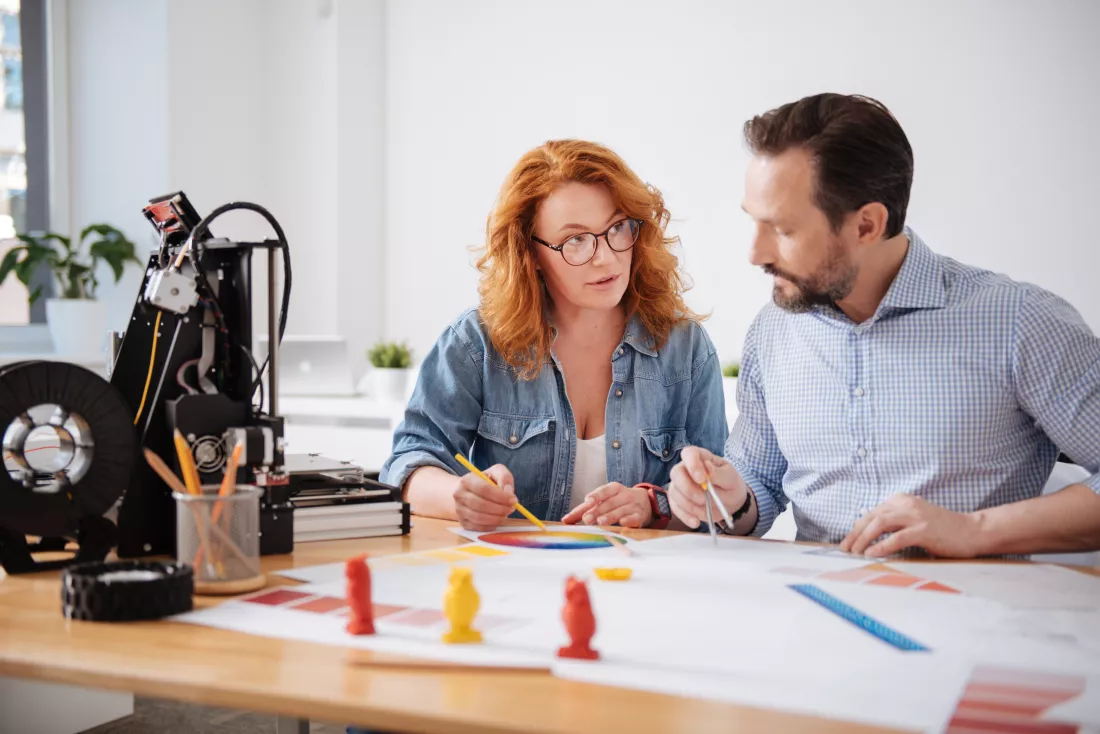 nice-serious-professional-colleagues-sitting-table-doing-some-drawings-while-working-together