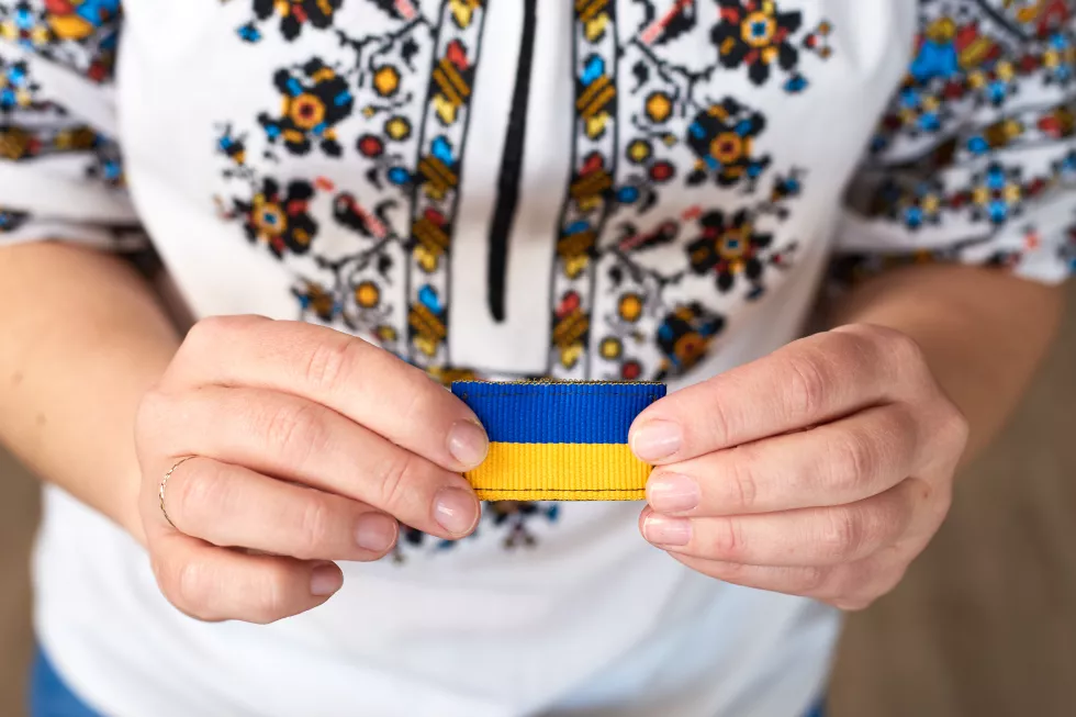 female-traditional-ukrainian-clothes-hold-hands-ribbon-with-ukrainian-flag