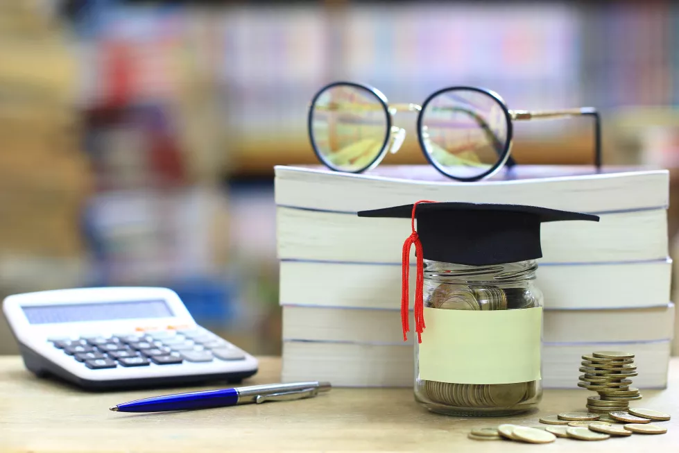 graduation-hat-glass-bottle-bookshelf-library-room-saving-money-education-concept