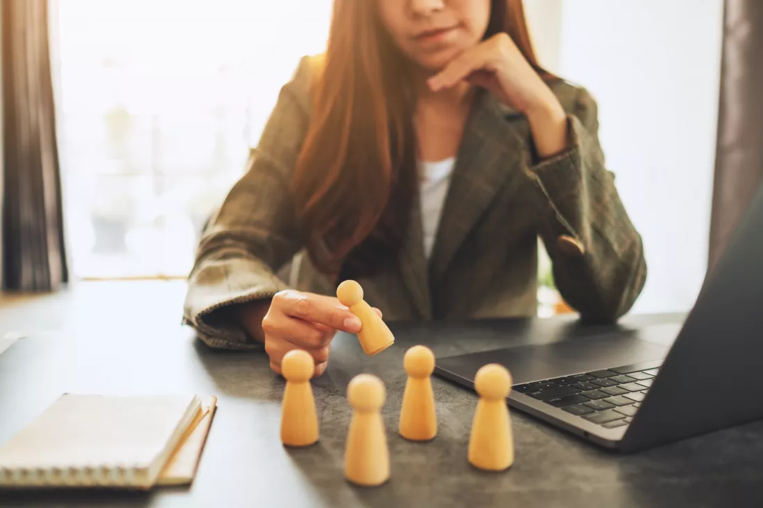 businesswoman-leader-choosing-wooden-people-from-group-employees-office