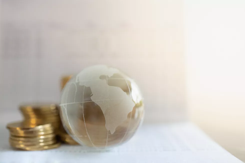 global-business-money-financial-concept-closeup-glass-world-ball-with-stack-gold-coins-bank-passbook-with-copy-space