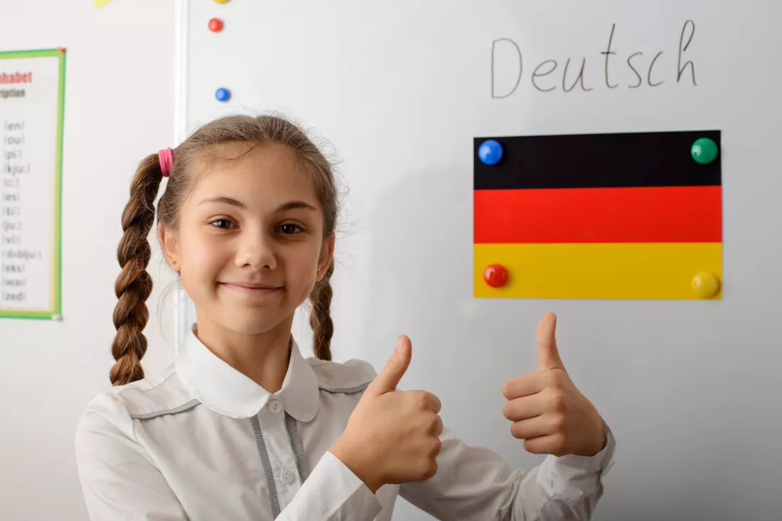 girl-showing-thumbs-up-near-flag-germany