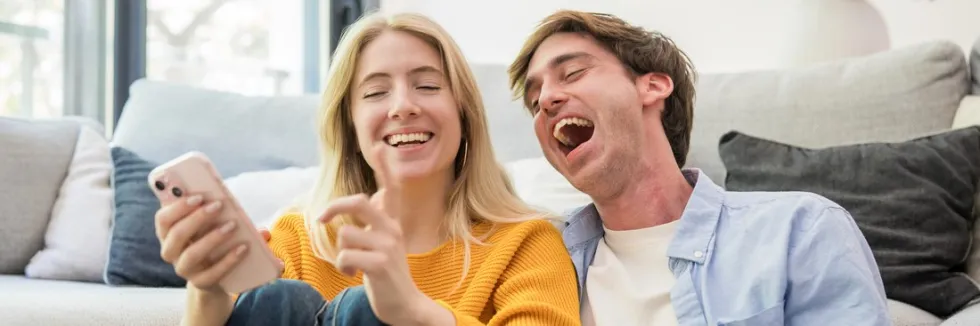 studentka-i-student-smieja-sie-z-wiadomosci-w-telefonie