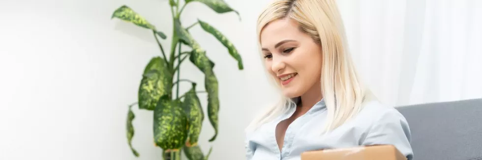 e-commerce-on-international-markets-usmiechnieta-kobieta-z-laptopem-i-paczka-zamowienie