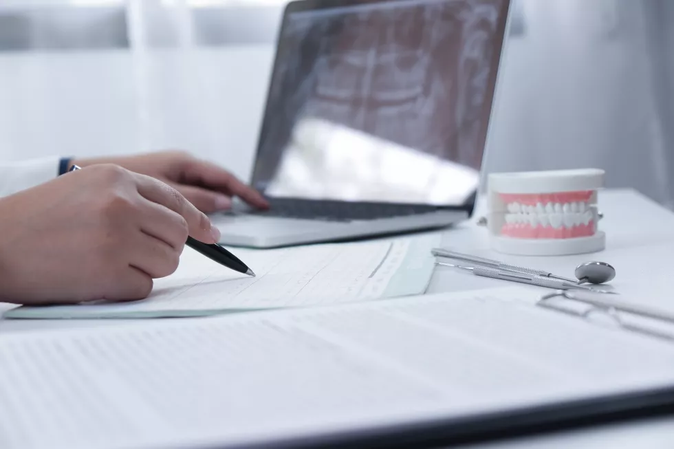 cropped-image-dentist-working-laptop-desk