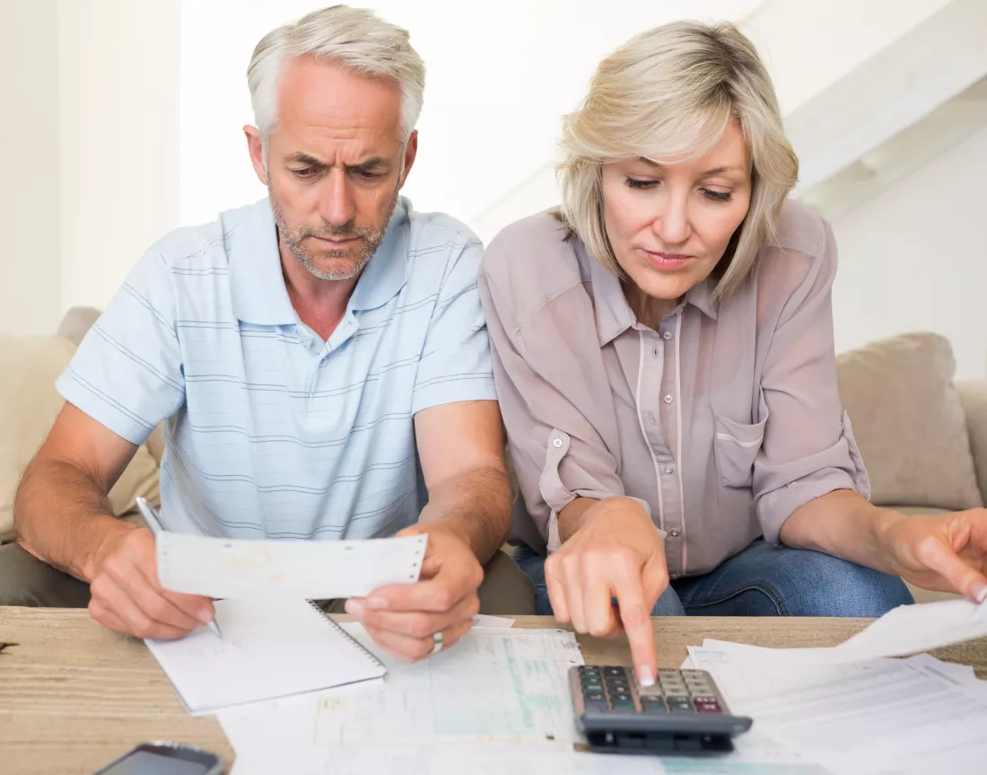concentrated-mature-couple-with-bills-calculator-home