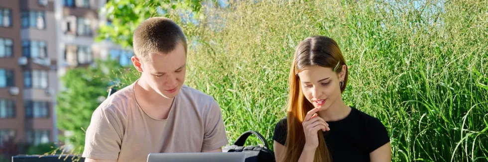 studentka-i-student-opracowuja-wyniki-ankiety-siedzac-na-zewnatrz