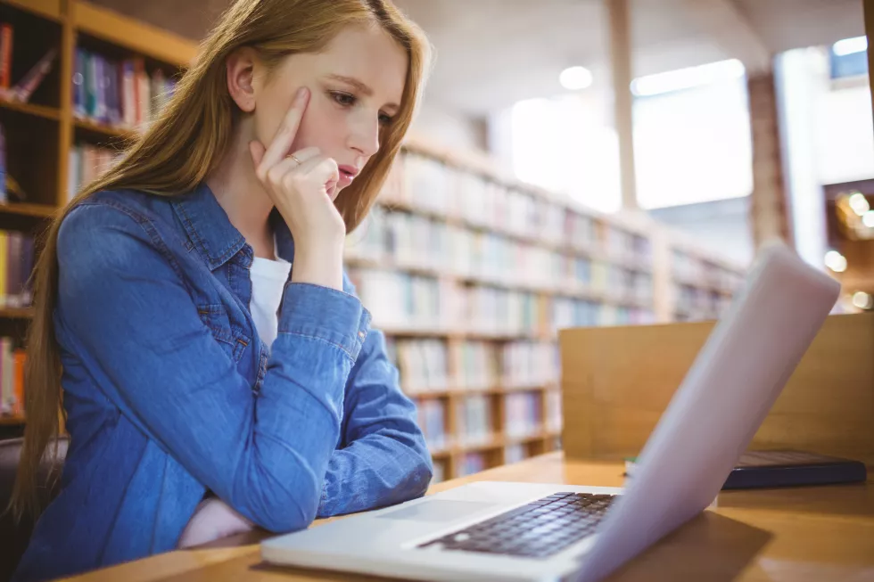 focused-student-using-laptop-library