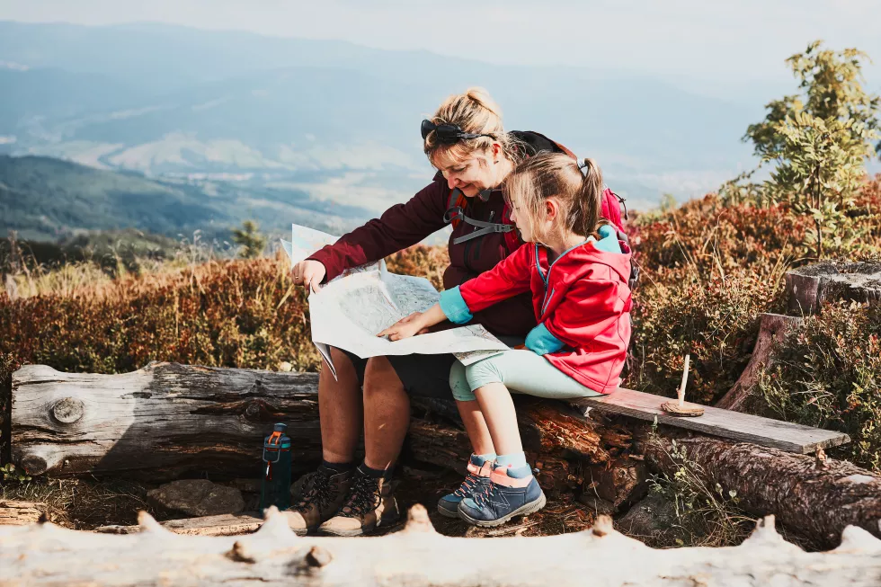 family-trip-mountains-mother-her-little-daughter-examining-map-taking-break-trip