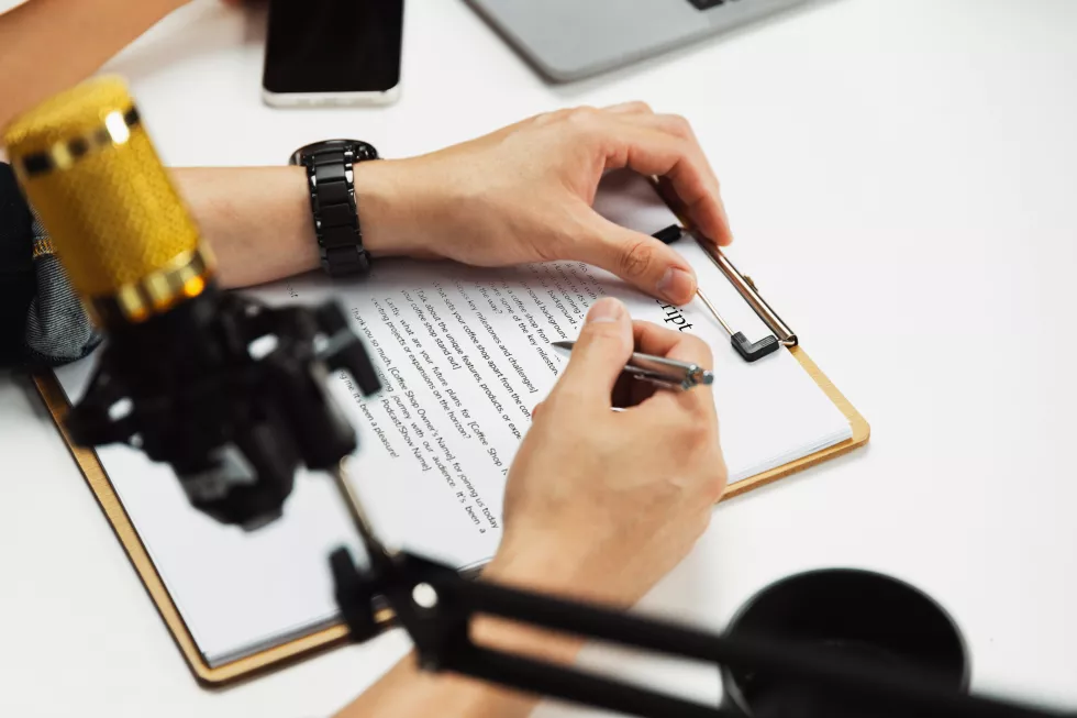 selective-focus-hands-writing-script-note-radio-influencer-host-infobahn