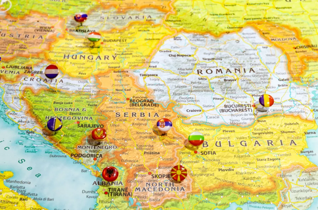 Mapa Polwyspu Balkanskiego z flagami panstw wpietymi w stolice