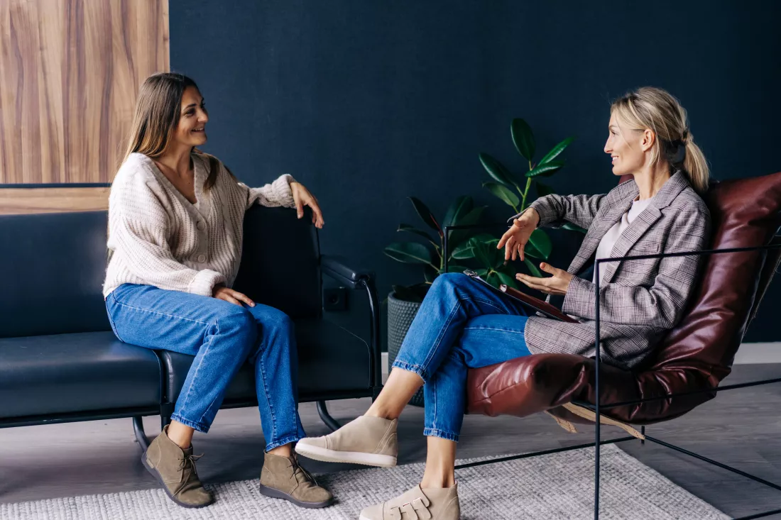 two-modern-stylish-women-are-sitting-office-discussing-ideas-implementation-plans