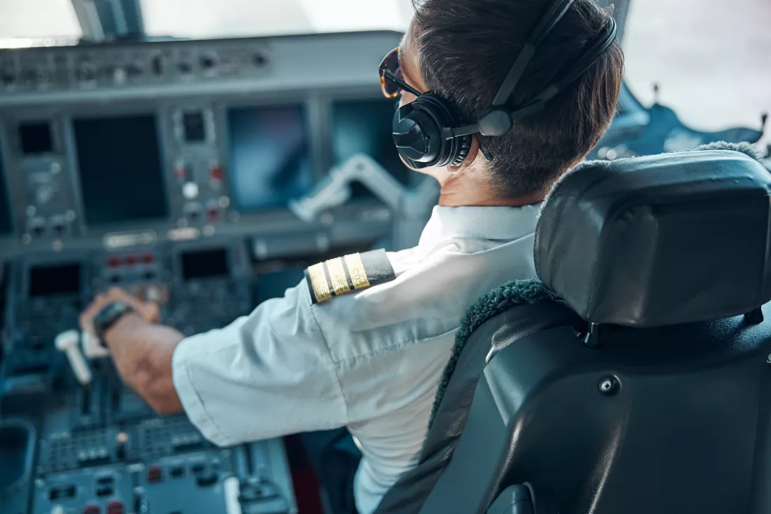 top-view-man-aviation-uniform-earphones-sitting-control-switching-rudder-while-taking-off