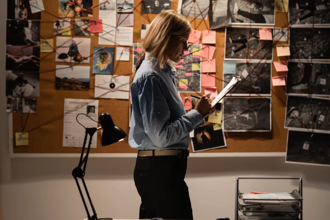serious-female-detective-working-her-office-with-evidence