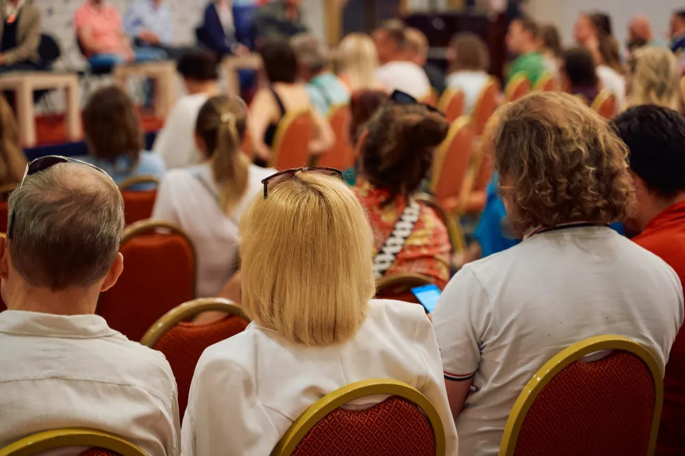 Publiczność słuchająca prelegenta w sali konferencyjnej