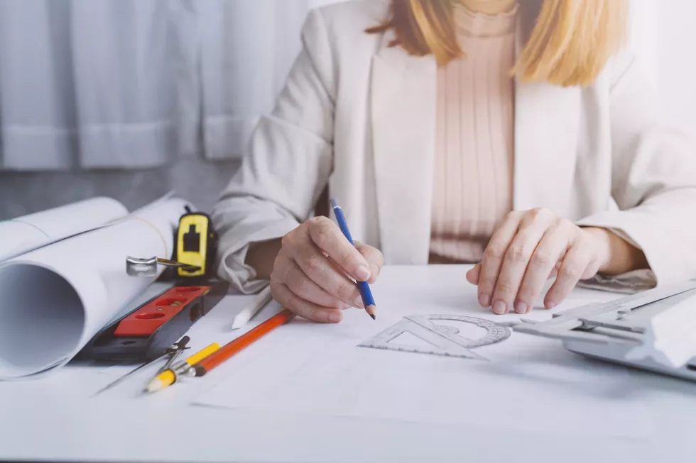 business-hand-working-laptop-with-architectural-project-construction-site-office-desk-office