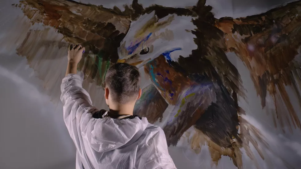 artist-designer-draws-eagle-wall-craftsman-decorator-paints-picture-with-acrylic-oil-color-painter-painter-dressed-paint-coat-indoor-dark-magic-cinematic-look