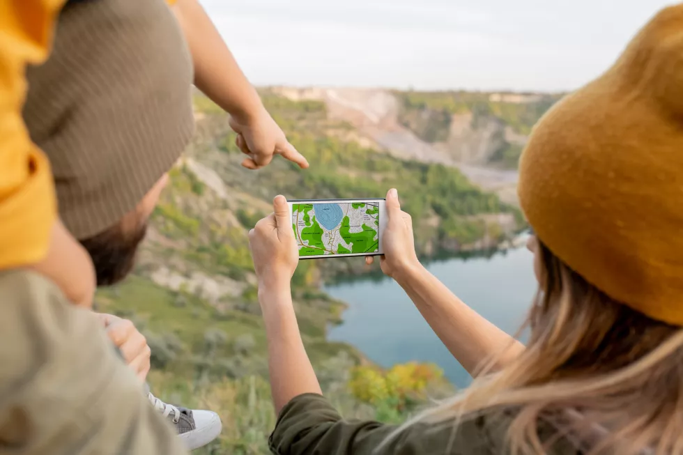 hand-little-boy-pointing-smartphone-screen-with-map-held-by-his-mother-standing-front-river-choosing-where-go