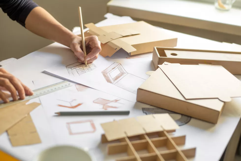 designer-draws-mockup-crafting-cardboard-box